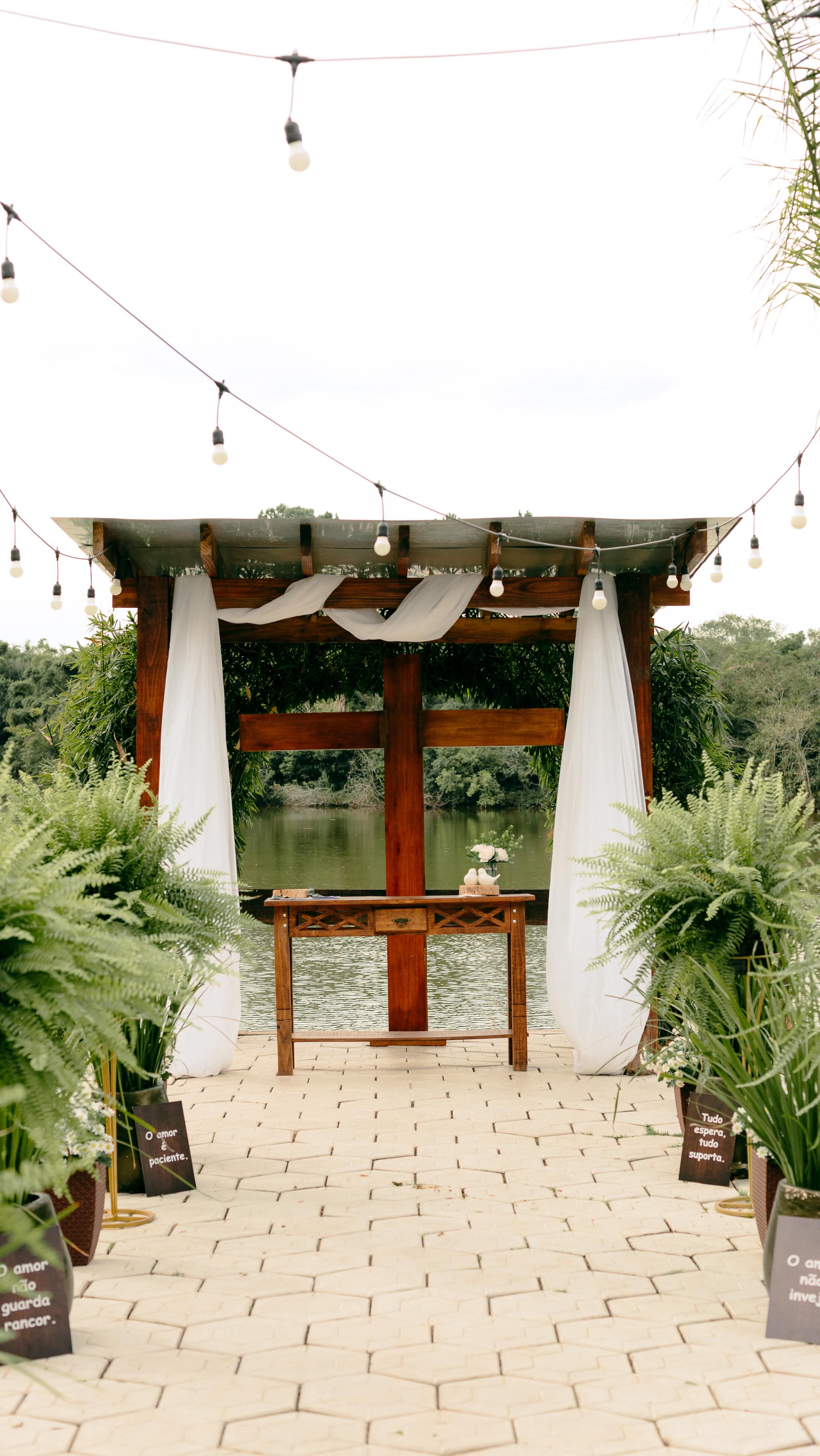Pérgola de madeira com cortinas diante do lago